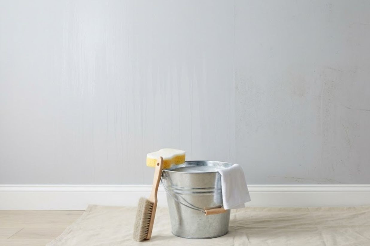 Paint, brushes and supplies ready against a wall before prep work