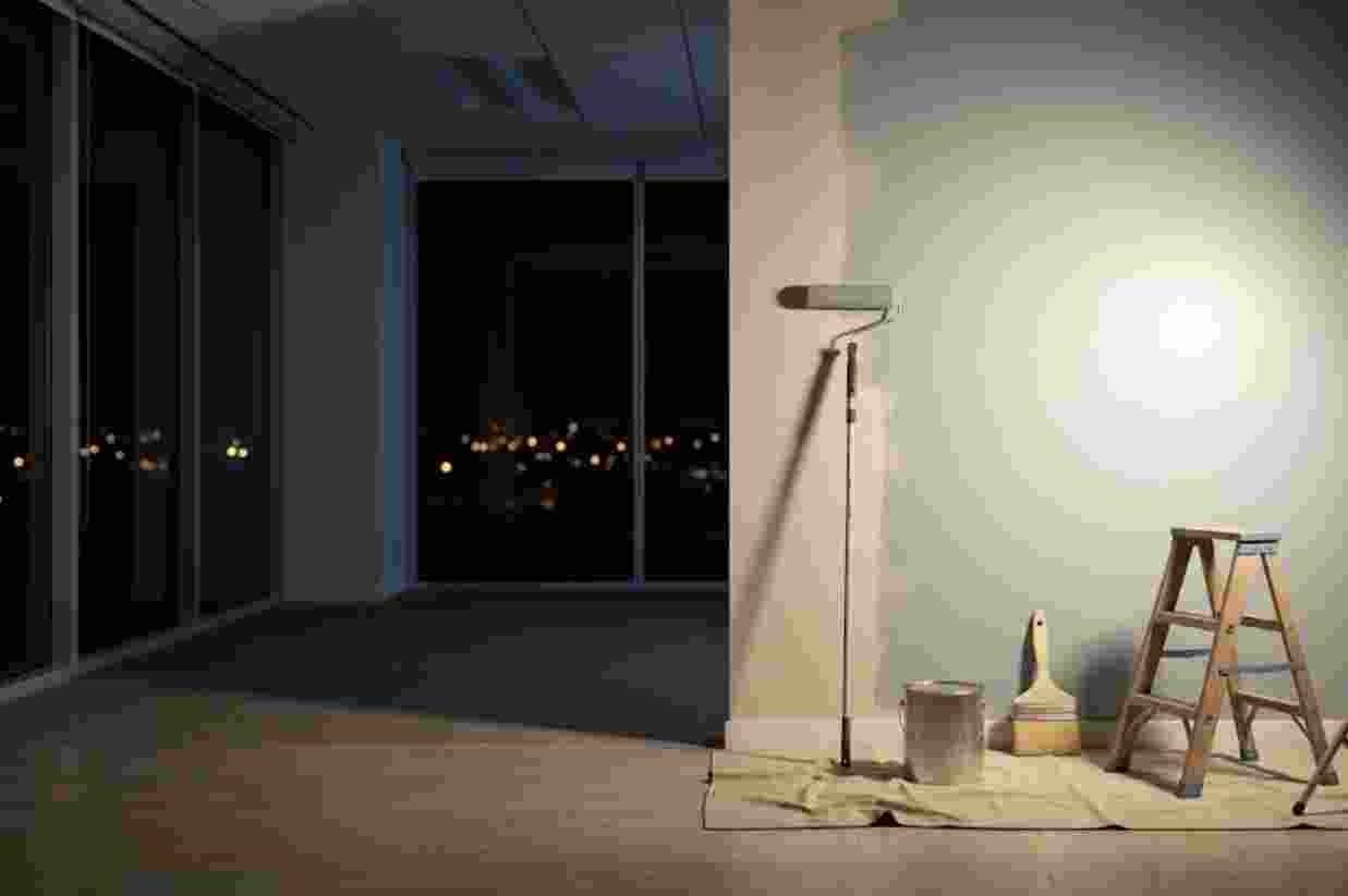 A painter working under lights in an office at night
